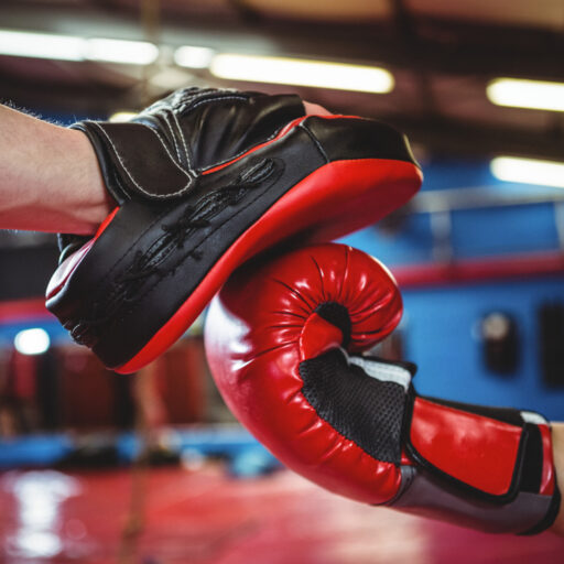 female boxer practicing with trainer