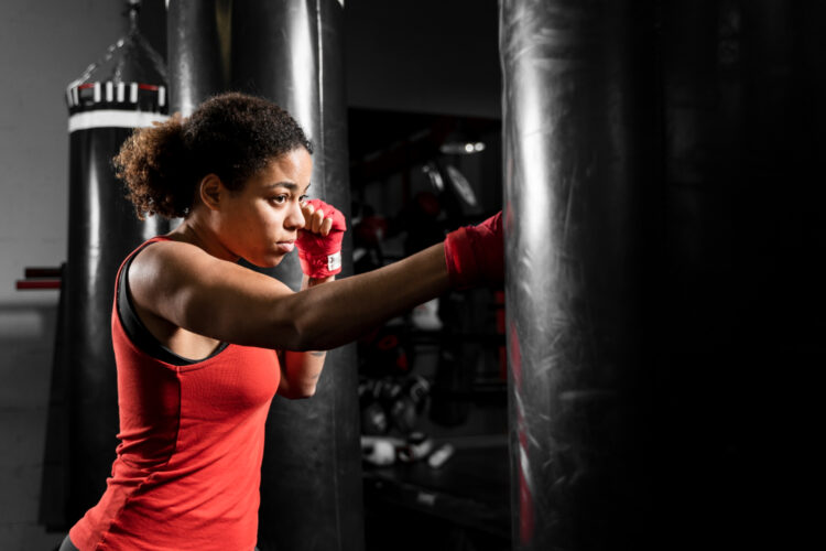 sideways athletic woman training boxing center